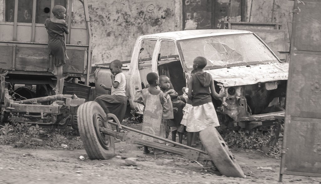 Kids play in a scrap yard on a Saturday.